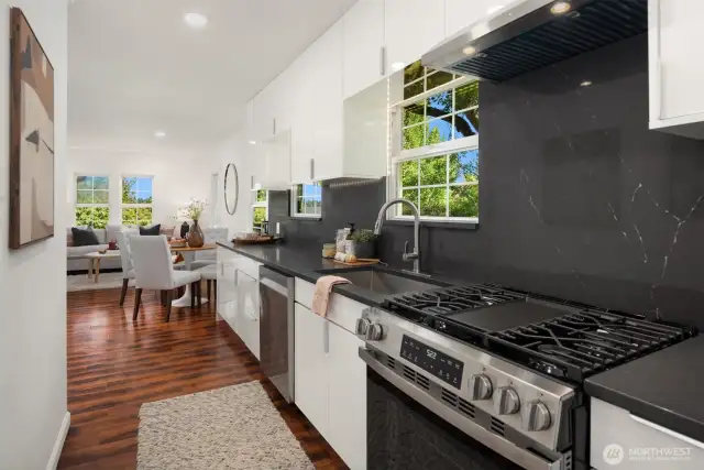 Gas cooking with a center burner/griddle has a quartz backsplash for easy maintenance.