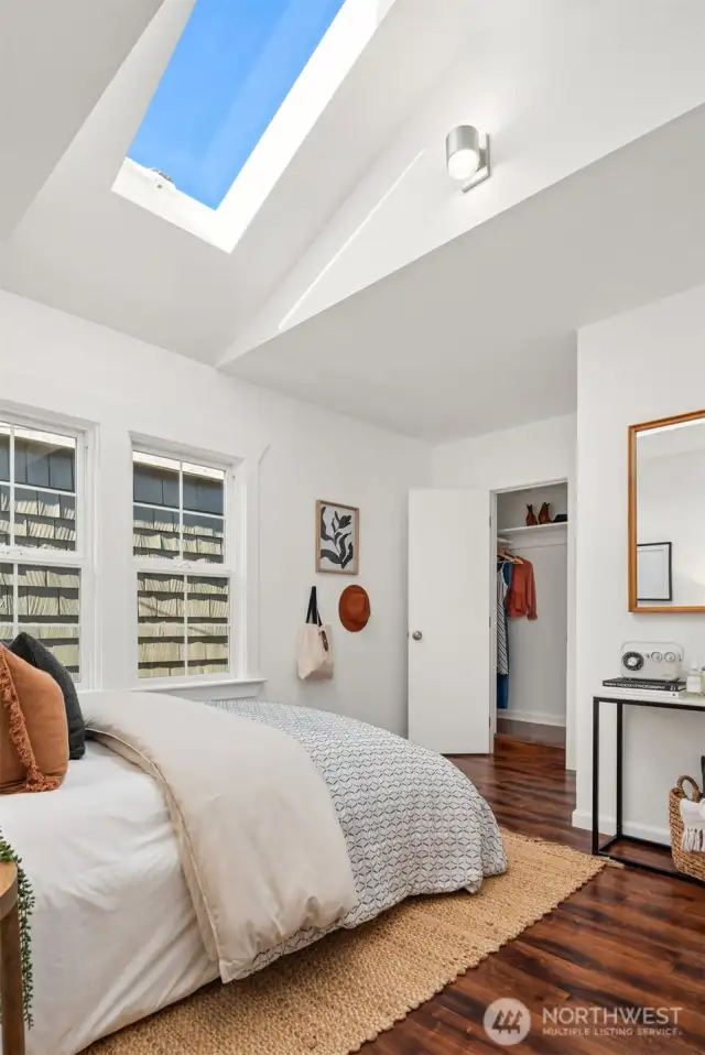 The vaulted ceiling in the primary bedroom features a large skylight.