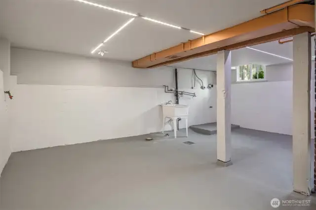The basement features an interior staircase and is fully sheetrocked. The washer and dryer go next to the laundry sink. A brand new hi-efficiency furnace and water heater are unseen to the right.