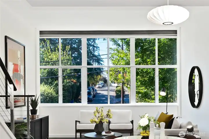 Incredible wall of windows let's the sun shine through this home's main level. Notice the green views looking west onto Lee St. The main level sits on the 2nd floor of the building for added privacy and peace. Welcome home.
