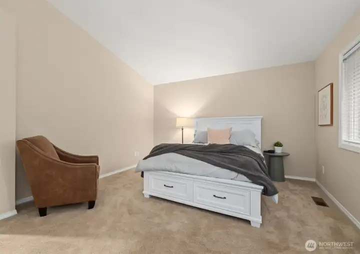 Large primary bedroom upstairs with vaulted ceilings.