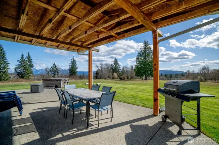Large covered patio on ADU includes hot tub and outdoor shower