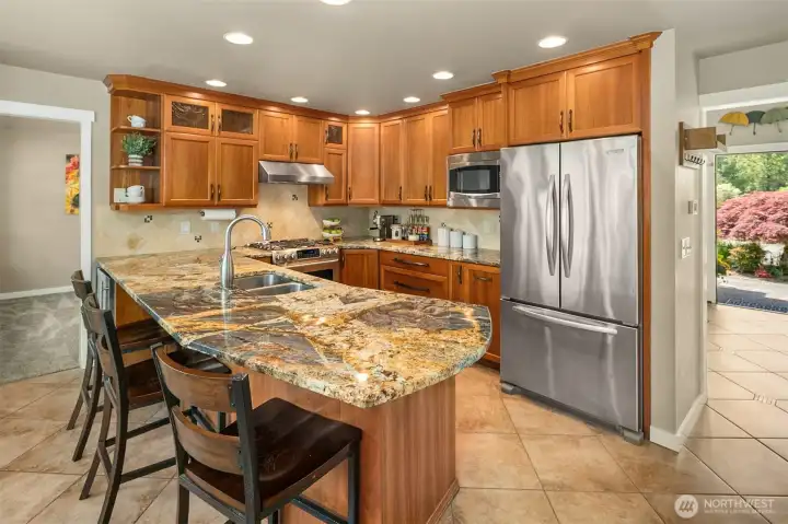 Kitchen boasts SS appliances, cherry cabinets and bar