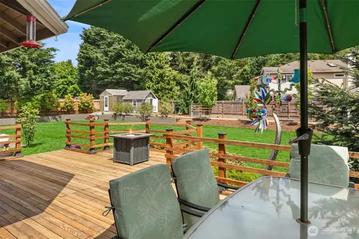 Expansive backyard has Deck and Patio, Blueberriees and green house