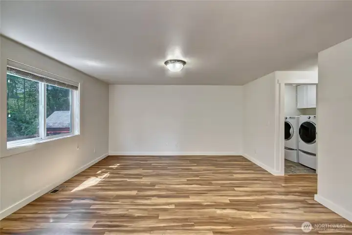 View from dining area into living area, hallway on the right is entry to laundry with a powder room around the corner and at the end of the hallway is the entrance to the gargae. View from dining area into living area, hallway on the right is entry to laundry with a powder room around the corner and at the end of the hallway is the entrance to the gargae.