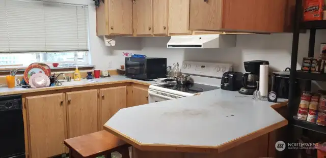 Huge Kitchen with Glass Top Range Oven and Breakfast Bar Eating Area.
