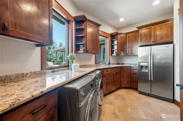 Beautifully designed utility room, complete with ample storage cabinetry, counter space, and an extra refrigerator for all your convenience needs. Functional and stylish, this space is perfect for keeping your home laundered and organized.