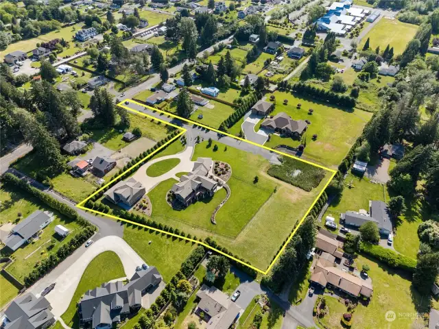 Discover serenity in this gated estate with vast grounds, a verdant lawn, a stunning home, and a separate detached garage with apartment—your personal paradise awaits.