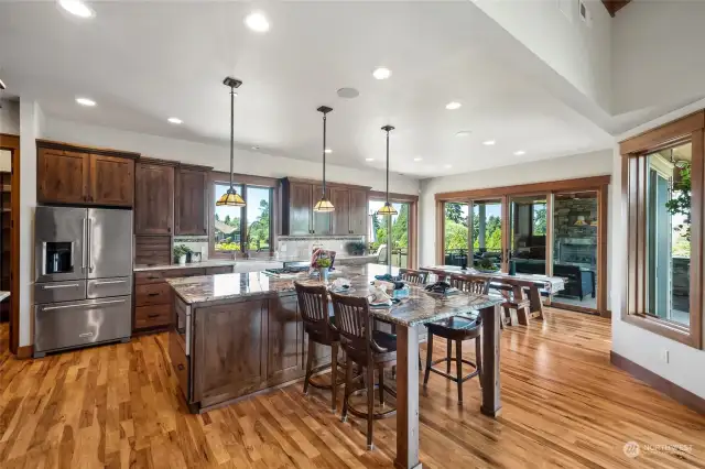 An extended seating area off the island creates a casual dining spot perfect for quick meals or social gatherings, while a connected dining room offers further space for both casual and formal dining.