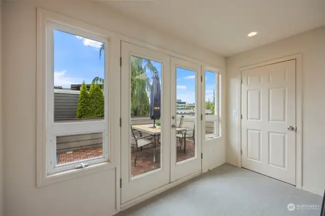 A landing at the top of the staircase leads outside to the rooftop deck.  There is a large storage closet just beside.