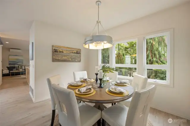 Dining room just to the other side of the fireplace with views of the landscaping and garden space below.