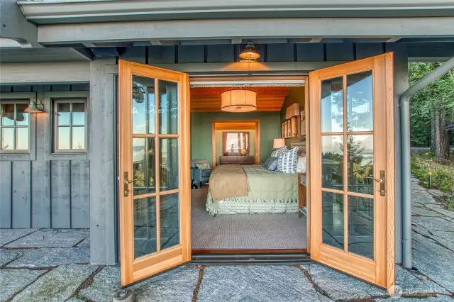Primary bedroom in Main House. Fench doors open out to outdoor flagstone patio.