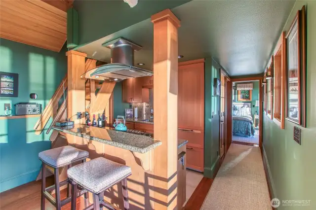 Main house-looking through kitchen, down a hallway and into the primary bedroom. Windows and closet space along the path. High-end appliances and custom cabinetry will encourage the master chef in you.