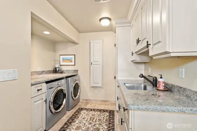 The Chef’s kitchen with oversized granite island, custom cabinets with pull out drawers offers hidden gems: trash compactor, double-oven, Sub-Zero refrigerator, undercounter lighting and floor lighting with westerly views at every turn.