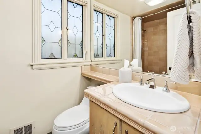 Full bath with stained-glass window.