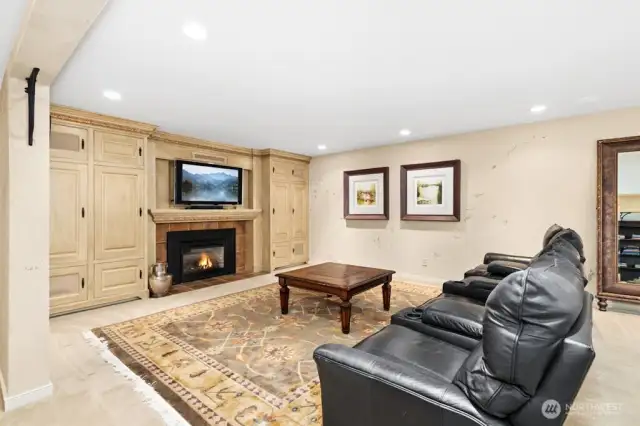 The spacious lower level is fully finished with custom built in bookshelves, gas fireplace, media room with TV, sub-woofer, and speakers.