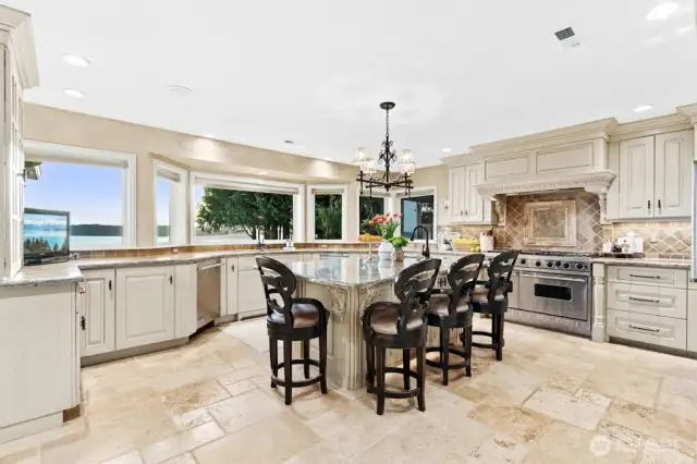The Chef’s kitchen with oversized granite island, custom cabinets with pull out drawers offers hidden gems: trash compactor, double-oven, undercounter lighting and floor lighting with westerly views at every turn.