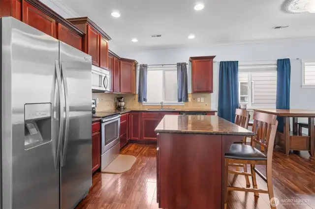 Island counter and stainless appliances in open Kitchen.