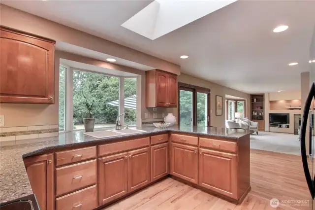 Kitchen with high-quality cabinetry and granite countertops and a bay window for nature views.