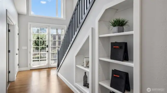 Customizable glass doors with built-in blinds lead you into a bright entryway with rich hardwood flooring. Functional cubbies line the stairs, ideal for showcasing personal touches or keeping essentials organized