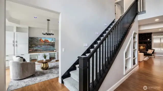 Walk into tall ceilings and a bold entry with a modern black-railed staircase and direct access to one of the home’s two spacious living areas!