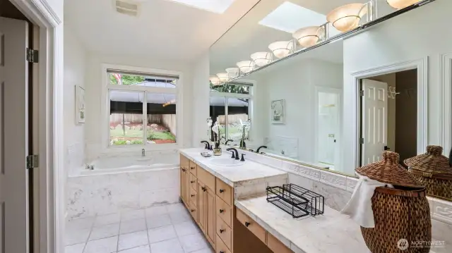 This en suite bathroom features a skylight and a walk-in closet that adds valuable extra storage to the primary living space!