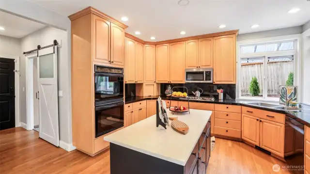 Both the pantry and laundry room feature stylish barn slider doors, conveniently located beside the kitchen, which boasts a double oven and tall cabinetry for added storage and functionality
