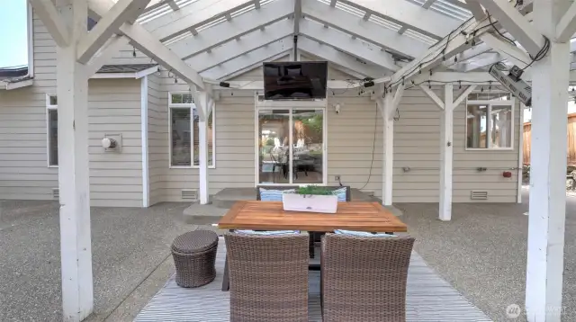 A large covered area welcomes you as you step outside, complete with a table and a cozy relaxation spot. Decorative lights enhance the ambiance, and there’s plenty of space to add a screen, TV, or projector for extra entertainment!