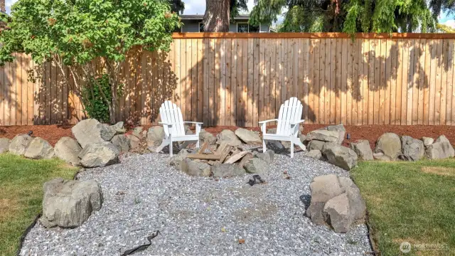 A firepit is featured in a separate backyard area, surrounded by decorative rocks for added style. It’s perfect for cozy late-night gatherings—whether making s’mores or simply enjoying the warmth under the stars