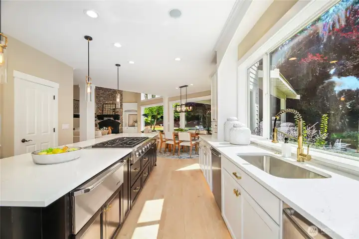 High-end chef’s kitchen w/ refinished cabinetry, expansive island, elegant pendant lighting—designed for both style & function.