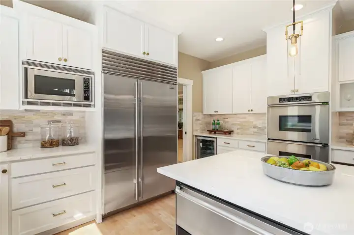 High-end chef’s kitchen w/ refinished cabinetry, expansive island, elegant pendant lighting—designed for both style & function.
