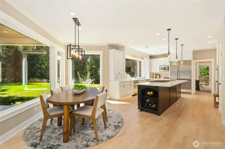 High-end chef’s kitchen w/ refinished cabinetry, expansive island, elegant pendant lighting—designed for both style & function.