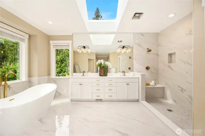 Luxurious primary suite w/ fireplace & spa-like ensuite featuring heated floors, freestanding tub, dual vanities & walk-in shower.