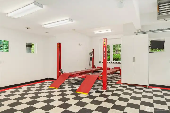 Oversized 5-car garage features abundant built-in storage and a heavy-duty 4-post lift rated to 9,000 lbs—ideal for auto enthusiasts