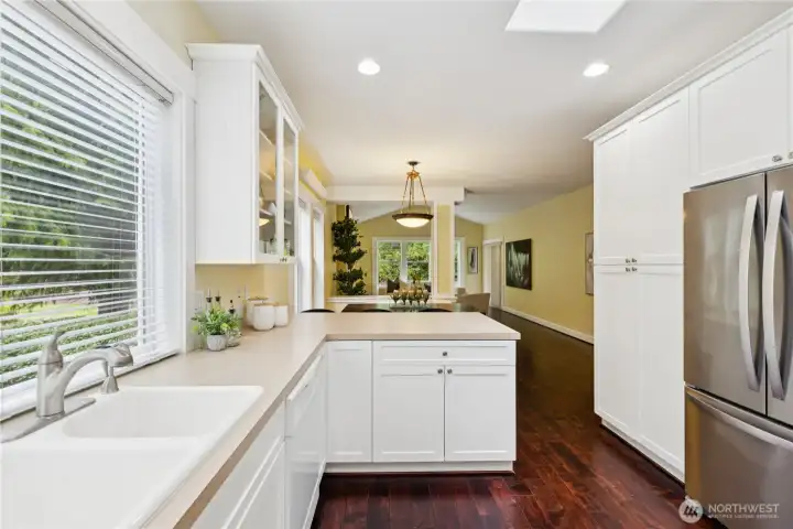 Featuring a double sink and a sleek, newer stainless steel refrigerator, this kitchen blends everyday functionality with modern appeal.