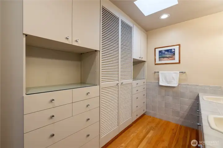 Ample en-suite bathroom storage with built-in double dressers & linen closet.