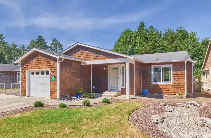 This charming single-level home features classic cedar shake siding, a covered front porch, and easy-care landscaping in a peaceful coastal neighborhood.