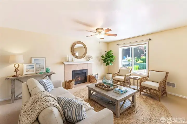 This light and comfortable living room features a cozy fireplace, soft neutral tones, and a welcoming layout with views of the landscaped yard.