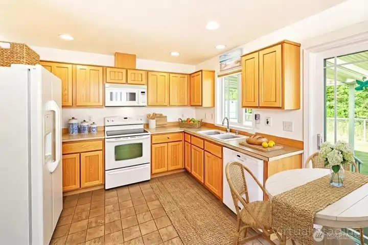 The kitchen features warm wood cabinetry, ample counter space, and a cozy eat-in area with natural light and easy access to the back deck.