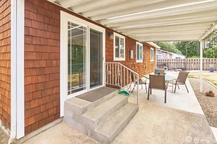 The covered back patio off the kitchen provides a comfortable outdoor gathering space for relaxing and entertaining.