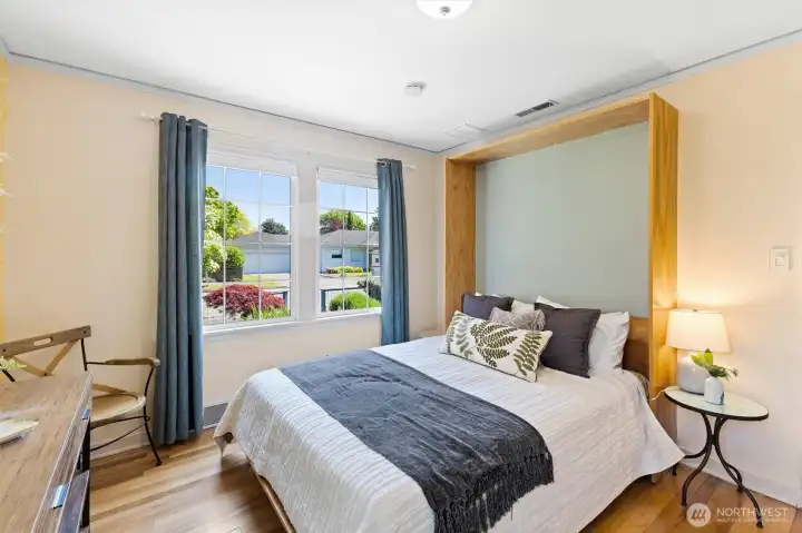 Comfortable main-level bedroom with Murphy bed, oversized windows and peaceful neighborhood views.