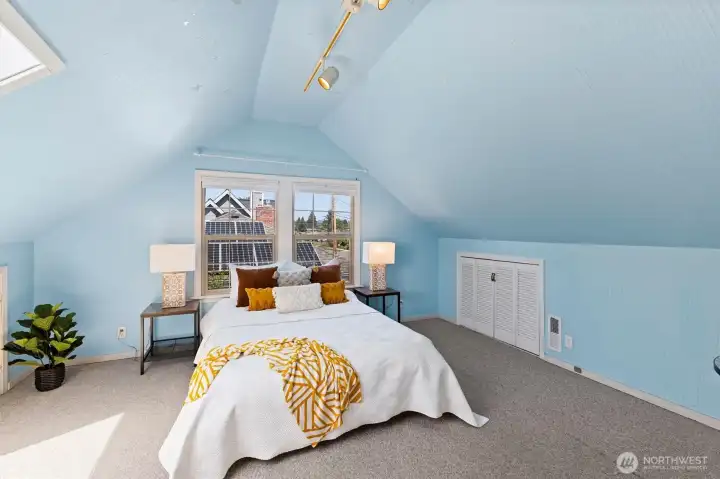 Spacious upper-level bedroom retreat with vaulted ceilings, soft natural light, and cozy charm.