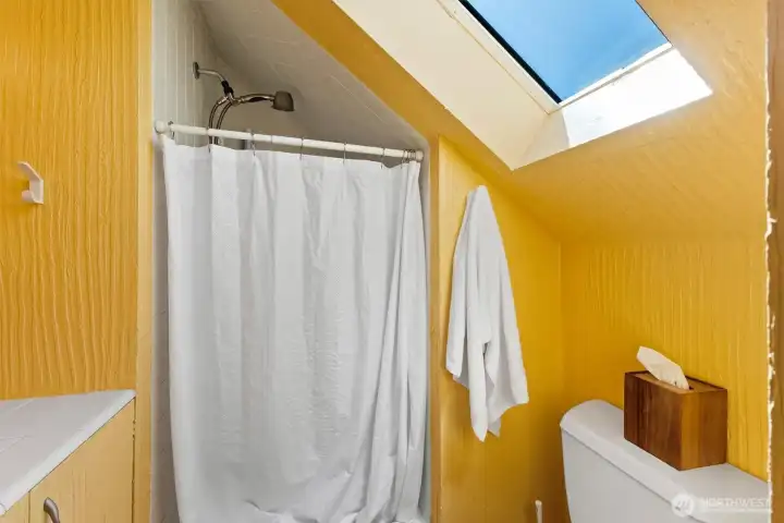 Charming upper-level bath with natural light and efficient use of space.