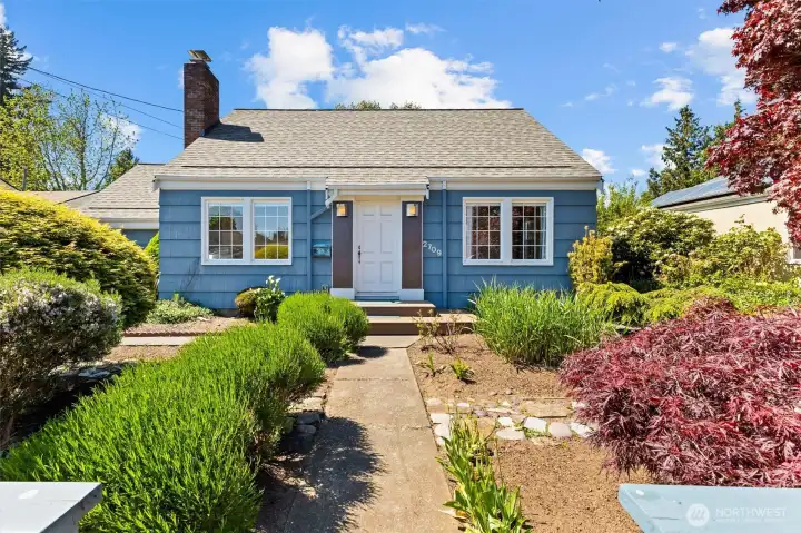 Storybook curb appeal with mature landscaping, colorful gardens, and classic architecture.