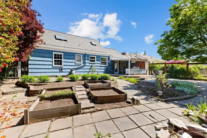 Raised garden beds and curated landscaping offer space for gardening, entertaining, and outdoor enjoyment.