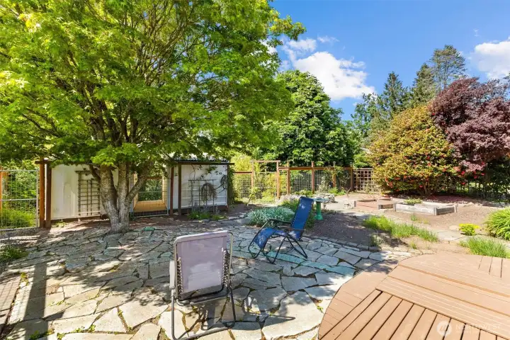 Beautifully landscaped grounds with established trees, stonework, and multiple functional outdoor spaces.