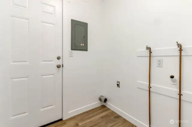 Laundry room near bedrooms with outside entrance door.