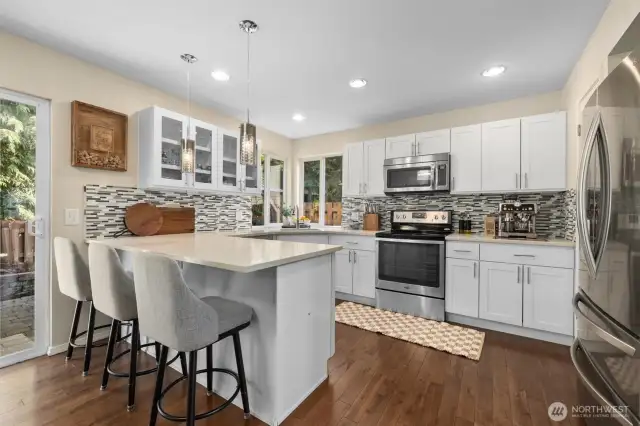 Modern kitchen w/ Shaker cabinets, Carerra quartz countertops with peninsula seating.