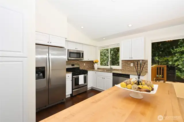 Slab granite surfaces & stainless-steel appliances make cooking a joy.