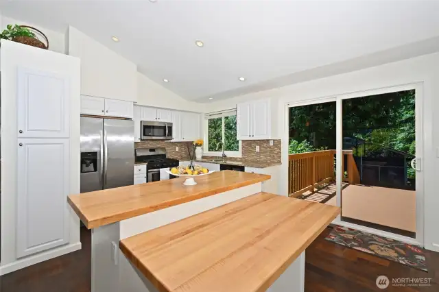 Soaring ceilings, stainless appliances, a butcher block island, and designer tile work make the kitchen a cook's delight.